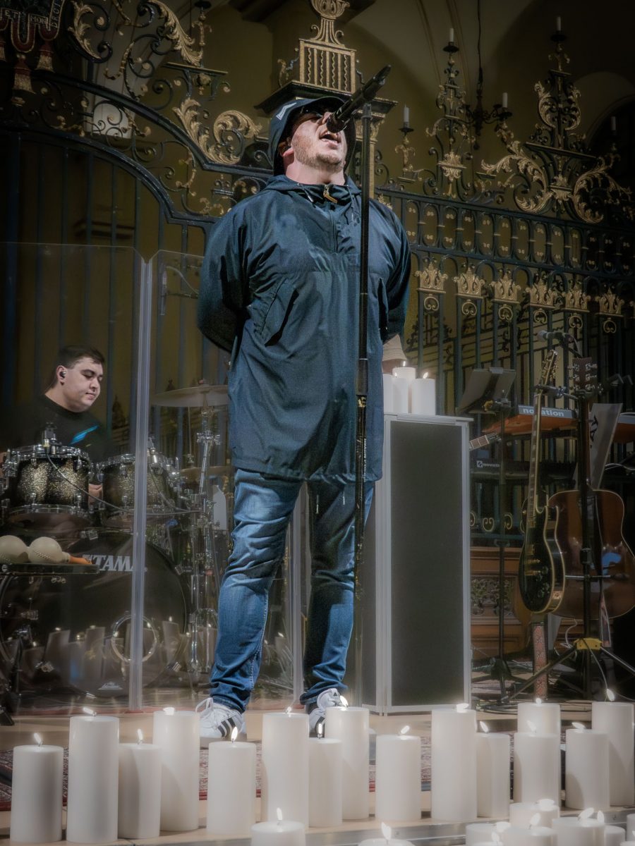 The lead singer of the Oasis tribute band performing by candlelight at derby cathedral