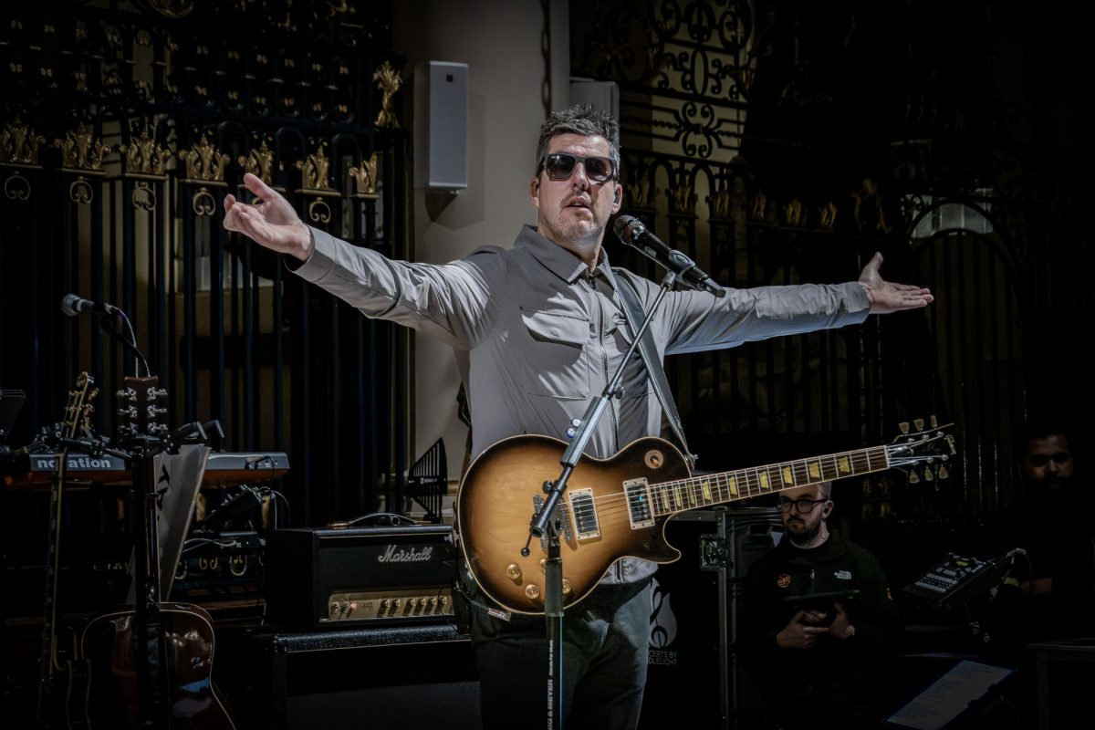 The lead guitarist of the Oasis tribute band performing by candlelight at derby cathedral
