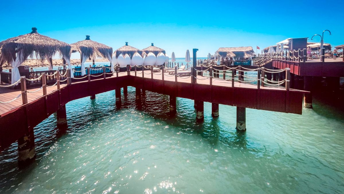 Overwater cabanas with thatched roofs and loungers at the Titanic Mardan Palace in Antalya overlooking the turquoise sea