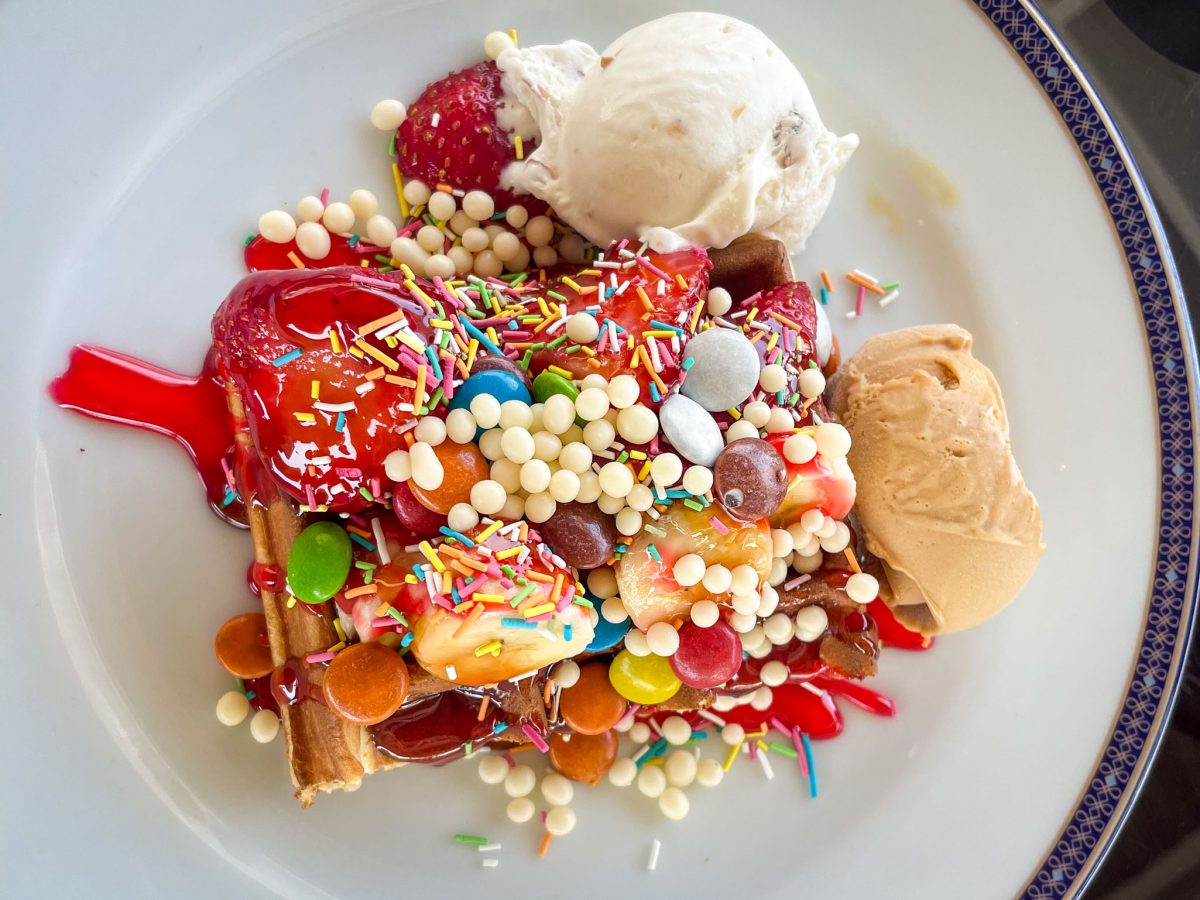 A colourful waffle dessert topped with strawberries, banana, sprinkles, candies, sauce and two scoops of ice cream at Titanic Mardan Palace in Antalya, Turkey
