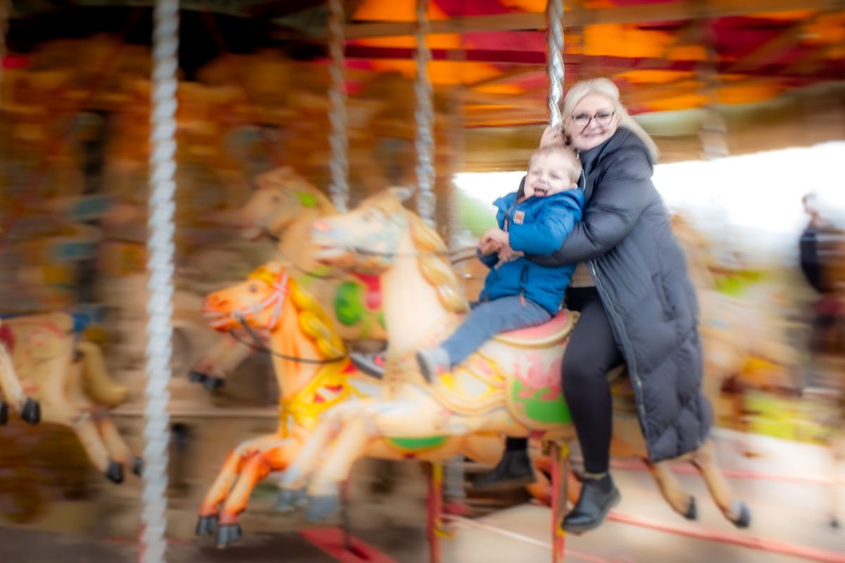 Woman and young boy riding the carousel at Wheelgate Park in Nottinghamshire.