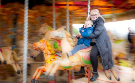 Woman and young boy riding the carousel at Wheelgate Park in Nottinghamshire.