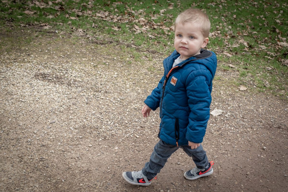 Young boy walking between rides at Wheelgate Park in Nottinghamshire.
