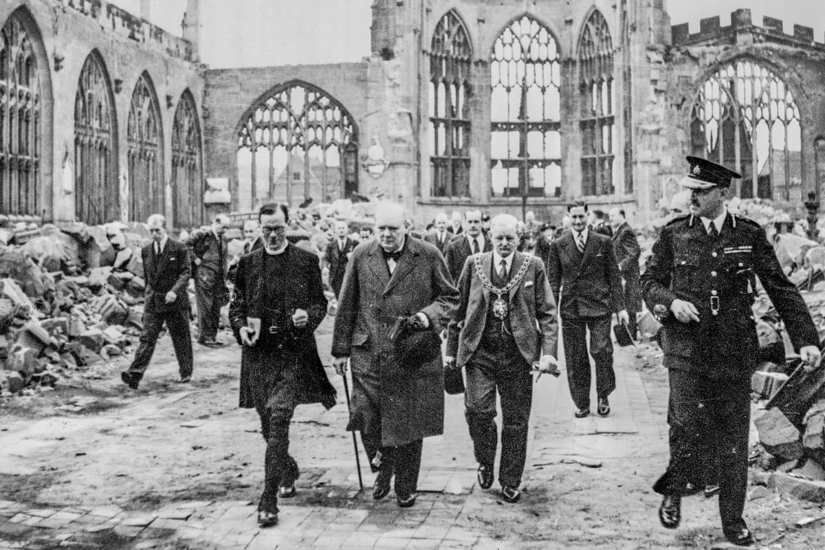 Prime Minister Winston Churchill walking through the rubble of Coventry Cathedral with officials after the Blitz.