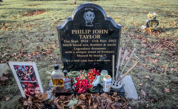 Full view of Phil Taylor's grave, showing the headstone, flowers, and Jack Daniel's.