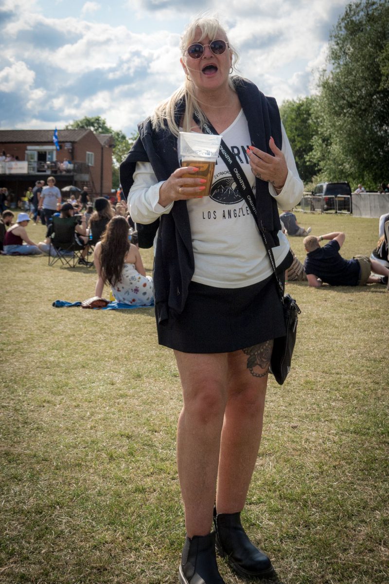 Woman holding a pint of beer standing in the grass at Spongefest