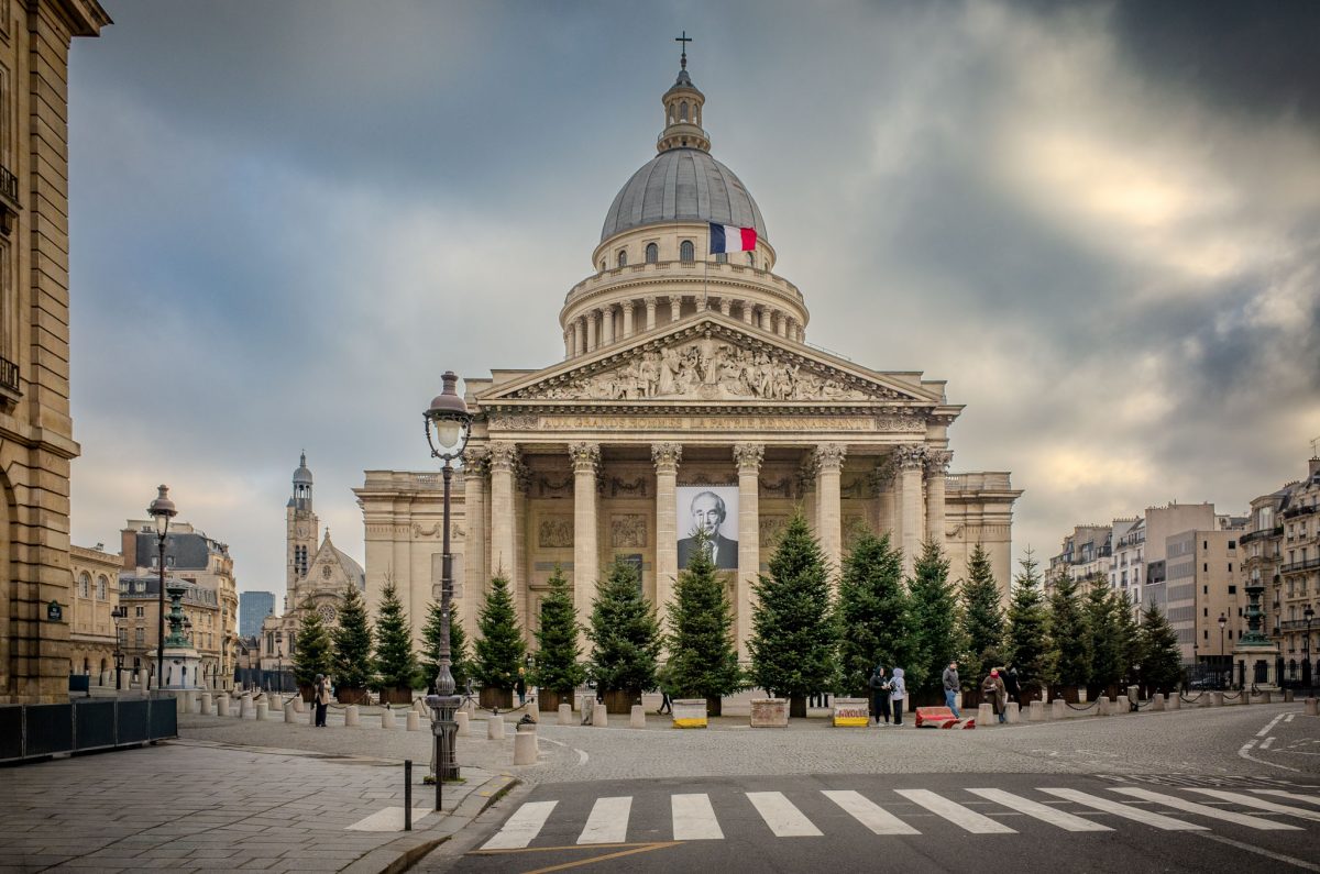 The grand neoclassical facade of the Panthéon in Paris under a cloudy sky.