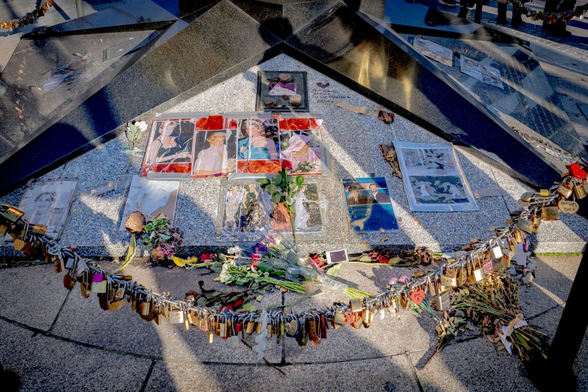 Photographs of Princess Diana, flowers, and locks left at the Flame of Liberty base.